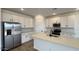 Modern kitchen with white cabinets, stainless steel appliances, tile backsplash, and a large kitchen island at 15761 W Beryl Ave, Waddell, AZ 85355