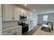 Close up view of a kitchen with white cabinets, quartz countertops, and stainless steel appliances at 15761 W Beryl Ave, Waddell, AZ 85355