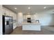 The spacious kitchen features white cabinets, stainless steel appliances, and an island at 15761 W Beryl Ave, Waddell, AZ 85355
