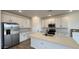 Kitchen boasts white cabinets, a stainless steel refrigerator, and a large island at 15761 W Beryl Ave, Waddell, AZ 85355