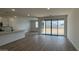 Bright living room featuring an open floor plan, wood-look tile flooring, and sliding glass doors to the backyard at 15761 W Beryl Ave, Waddell, AZ 85355