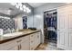 Bathroom featuring ample cabinet space, a sink, mirror, and a walk-in closet at 162 N 225Th Dr, Buckeye, AZ 85326