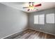 Neutral bedroom with ceiling fan, wood-look floors, and ample natural light at 162 N 225Th Dr, Buckeye, AZ 85326