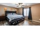 A cozy bedroom with a ceiling fan, wood-look flooring, and neutral paint at 162 N 225Th Dr, Buckeye, AZ 85326