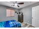 Cozy bedroom features wood-look flooring, ceiling fan, and a blue comforter at 162 N 225Th Dr, Buckeye, AZ 85326