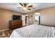 Bedroom featuring a large TV, neutral walls, wood flooring, and ample natural light at 162 N 225Th Dr, Buckeye, AZ 85326