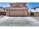 Two-car garage featuring decorative carriage lights and a concrete driveway at 162 N 225Th Dr, Buckeye, AZ 85326