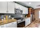 Modern kitchen with stainless steel appliances, granite countertops, and white cabinets for a clean look at 162 N 225Th Dr, Buckeye, AZ 85326