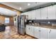 Well-lit kitchen with stainless steel refrigerator, granite counters, and ample cabinet space for storage at 162 N 225Th Dr, Buckeye, AZ 85326