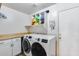 Well-organized laundry room with modern washer, dryer, white cabinets, and practical storage solutions for a functional space at 162 N 225Th Dr, Buckeye, AZ 85326