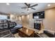 Spacious living room featuring a TV, a sectional sofa, wood floors, and a ceiling fan for a relaxing atmosphere at 162 N 225Th Dr, Buckeye, AZ 85326