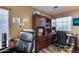 Functional home office space featuring a dark wood desk, cabinets, and natural light, conducive to productivity and focus at 162 N 225Th Dr, Buckeye, AZ 85326