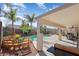 Relaxing backyard featuring a covered patio, outdoor seating, lush landscaping, and a refreshing pool at 16351 W Central St, Surprise, AZ 85388