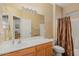 Well-lit bathroom with single sink vanity, large mirror, and shower with curtain at 16351 W Central St, Surprise, AZ 85388