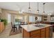 Sunlit kitchen featuring an island with a sink, dining area, and easy access to the outdoor patio at 16351 W Central St, Surprise, AZ 85388