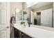 Bright bathroom featuring a mirror, a solid surface counter, and brown cabinets at 17190 W Bent Tree Dr, Surprise, AZ 85387