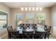 Inviting dining area with a dark wood table set, complemented by natural light streaming through multiple windows at 17190 W Bent Tree Dr, Surprise, AZ 85387