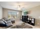 Comfortable living room featuring a sectional sofa, large windows, and a ceiling fan at 17190 W Bent Tree Dr, Surprise, AZ 85387