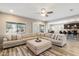 Cozy living room with a large sectional sofa, modern ceiling fan, and a seamless connection to the dining area at 17190 W Bent Tree Dr, Surprise, AZ 85387