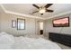 Stylish bedroom featuring a TV, ceiling fan, and a comfortable bed with neutral bedding at 17190 W Bent Tree Dr, Surprise, AZ 85387