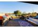 Outdoor patio area with full kitchen, built-in grill, a dining table set, a sofa and a view of the lake and golf course at 17721 E Bismark Lake Ct, Rio Verde, AZ 85263