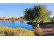 Picturesque pond with landscaping, a golf course in the background, and blue sky with clouds at 17721 E Bismark Lake Ct, Rio Verde, AZ 85263