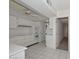 Well-lit kitchen with white cabinetry and appliances, tile floors, and a ceiling fan at 18034 N Highwood Ct, Sun City, AZ 85373