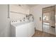 This laundry room features a washer, dryer, and water heater adjacent to the entrance to another room at 18034 N Highwood Ct, Sun City, AZ 85373