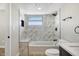 Bathroom featuring a tub with marble surround, tiled shower, and modern fixtures at 1913 E 1St Ave, Mesa, AZ 85204