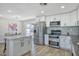 Modern kitchen with stainless steel appliances, white cabinets, quartz countertops, and an island with bar seating at 1913 E 1St Ave, Mesa, AZ 85204