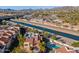 Stunning aerial view of a home with a pool, lush landscaping, and a canal nearby, set against a mountain backdrop at 1920 E Maryland Ave # 16, Phoenix, AZ 85016