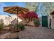 Relaxing brick-paved patio with shade umbrella, beautiful bougainvillea, potted plants, and custom art features at 1920 E Maryland Ave # 16, Phoenix, AZ 85016