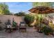 Charming back patio with brick pavers, comfortable seating, vibrant flowers, and relaxing shade umbrella at 1920 E Maryland Ave # 16, Phoenix, AZ 85016