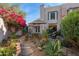 Picturesque backyard featuring lush landscaping, a shade umbrella, mature trees, and a charming home exterior at 1920 E Maryland Ave # 16, Phoenix, AZ 85016