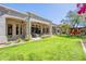 Expansive backyard featuring a covered patio, modern fire pit, and lush green lawn perfect for outdoor living at 22970 N 79Th Pl, Scottsdale, AZ 85255