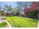 Lush backyard featuring vibrant flowers, mature trees, and a pergola creating a serene outdoor oasis at 22970 N 79Th Pl, Scottsdale, AZ 85255