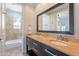 Bright bathroom featuring a dual vanity with stone counters and a bathtub with tile surround at 22970 N 79Th Pl, Scottsdale, AZ 85255