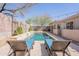 Backyard pool with lounge chairs, a travertine deck, water features, and mature landscaping, creating a tranquil escape at 22970 N 79Th Pl, Scottsdale, AZ 85255