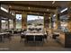 A covered outdoor dining area features stone columns, ceiling fans, and views of the desert landscape at 23750 N 126Th Pl, Scottsdale, AZ 85255