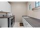 Spacious laundry room with sink, washer and dryer, cabinets, and a hanging rack at 2454 E Ebony Dr, Chandler, AZ 85286