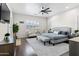 Bright main bedroom features a sitting area, ceiling fan, light gray walls, and dark wood flooring at 2454 E Ebony Dr, Chandler, AZ 85286