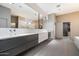 Modern bathroom featuring a large mirror, dual sinks, sleek cabinetry, and tiled flooring at 25 W Frier Dr, Phoenix, AZ 85021