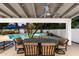 Comfortable outdoor seating under covered patio with a ceiling fan overlooks the refreshing pool and surrounding landscape at 25 W Frier Dr, Phoenix, AZ 85021