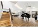 Open living area featuring hardwood floors, a grand piano, and soaring ceilings for an airy feel at 25 W Frier Dr, Phoenix, AZ 85021