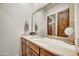 Bathroom with wooden vanity, marble countertop, and a large mirror at 25436 N 114Th St, Scottsdale, AZ 85255