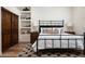 Bedroom featuring wood floors, black metal bedframe, and built in display shelves at 25436 N 114Th St, Scottsdale, AZ 85255