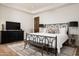 Bright bedroom boasts wood floors, iron bed, and modern black accents at 25436 N 114Th St, Scottsdale, AZ 85255