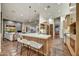 Open-concept kitchen featuring a marble island with seating and views of the living room and fireplace at 25436 N 114Th St, Scottsdale, AZ 85255