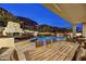 Outdoor pool area with a fireplace, seating, and an outdoor kitchen, perfect for entertaining and relaxing at 25436 N 114Th St, Scottsdale, AZ 85255