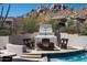 Outdoor poolside patio area with a built-in fireplace and comfortable seating at 25436 N 114Th St, Scottsdale, AZ 85255